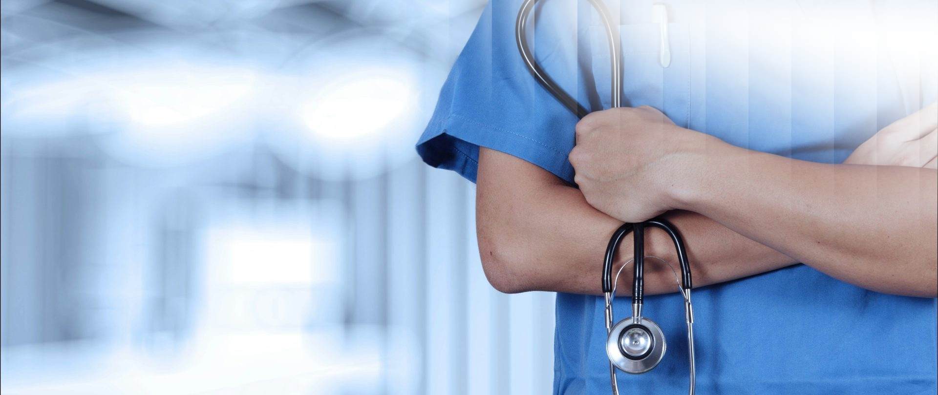 a person in scrubs with a stethoscope on their arm